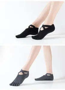 Calcetines de yoga antideslizantes de cinco dedos con tiras cruzadas y suela de puntos.