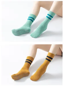 Detail view of non-slip yoga socks with ribbed cuffs, striped pattern and grip dots on sole.