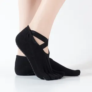 Calcetines de yoga antideslizantes de algodón negro de cinco dedos con tirantes cruzados fitness.