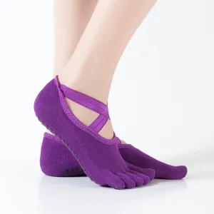 Cómodos calcetines de yoga de algodón con cinco dedos, correas cruzadas y suelas antideslizantes.