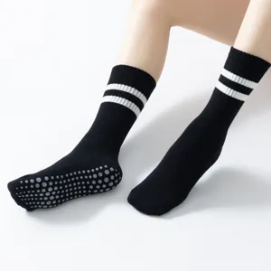 Non-slip yoga pilates socks for women, black long crew socks with grip soles and white stripes.