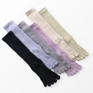 Detailed view of colorful five-toe yoga socks, comfortable ribbed mid-calf design.