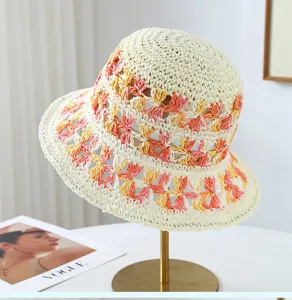 Primer plano detallado de un elegante sombrero de paja tejido a mano con flores coloridas.