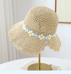 Cappello di paglia intrecciato a mano con margherite blu e bianche per protezione solare.