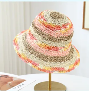 Detailed view of a colorful rainbow straw bucket hat with wide brim, perfect for summer resort.