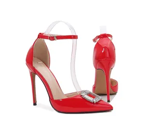 Zapatos de tacón alto en charol rojo con punta fina y hebilla cuadrada de diamantes.