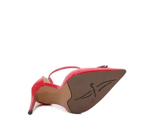 Sandalias de tacón de aguja con punta en charol rojo y brillantes detalles de pedrería.