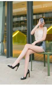 Close-up detail of women's black patent high heels featuring dazzling crystal square buckles.