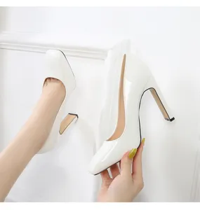 Close-up detail of white patent leather square toe chunky high heels shoe design.