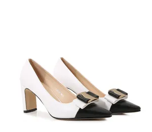 Detailed close-up of stylish black and white block heel pumps with elegant bow buckle.