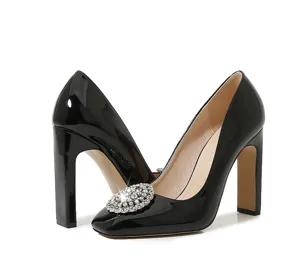 Black patent leather high heels with square toe and sparkling rhinestone buckle for party.