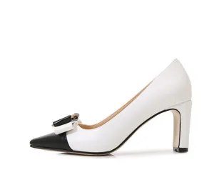 Close-up detail of stylish black and white color block high heel pumps with bow accent.