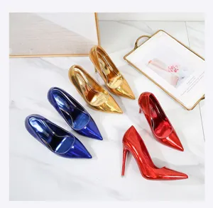 Detailed view of glossy patent leather pointed toe high heels in vibrant blue, gold, and red.
