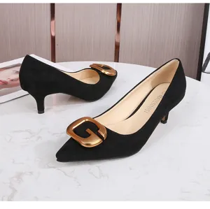 Vista detallada de elegantes zapatos de tacón en ante negro con llamativa hebilla dorada.