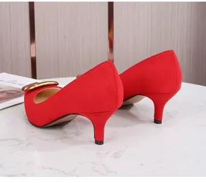 Vista detallada de zapatos de tacón medio en ante rojo con hebilla metálica para mujer.