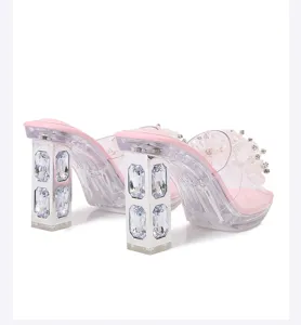 Close-up view of clear chunky heels featuring dazzling rhinestones and chic pink insoles.