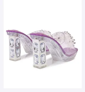 Detail shot of clear chunky high heels featuring crystal embellishments and floral details.