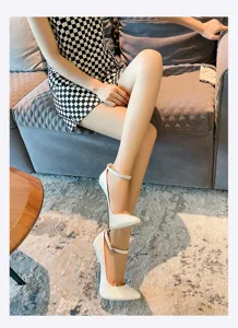 White patent leather high heels with 16cm metal stiletto heel and ankle strap detail.