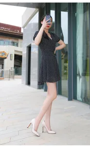 Outdoor detail shot of a woman wearing stylish chunky high heels and a polka dot dress.
