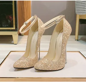 Vista detallada de zapatos de tacón de aguja con purpurina dorada y correas finas.