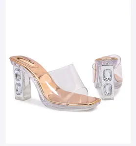 Detail shot of clear chunky high heel sandals with embedded rhinestones and gold insole.