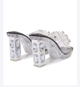 Detail view of crystal rhinestone chunky heel transparent sandals featuring floral straps and gems.