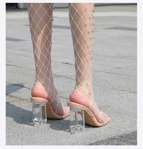 Primer plano de tacones altos transparentes con tirantes combinados con medias de red.
