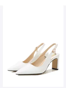 Décolleté slingback in vernice bianca con punta affilata, tacco largo e ciondolo in metallo.