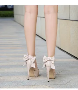 Detailansicht beige Lackleder High Heels mit großer Schleife und Stilettoabsatz.