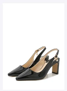 Dettaglio in primo piano di scarpe decollete slingback in vernice nera con tacco grosso.