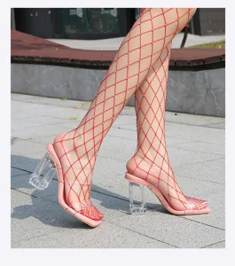 Sandalias de tacón alto transparentes vista detallada con tiras y medias de rejilla.