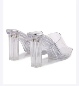 Detailed view of transparent high heel mules with clear chunky fluted heels and silver trim.