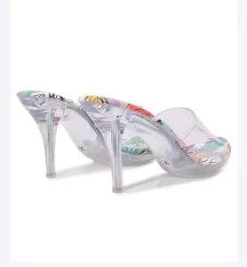 Sandalias de tacón alto transparente con suela colorida estampada y puntera abierta.