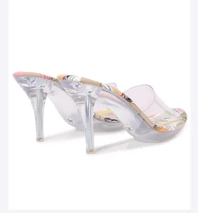 Mules de tacón alto transparente con suela interior estampada colorida y elegante.