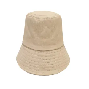 Detailed view of a plain beige cotton bucket hat, showing fine stitching and soft fabric texture.