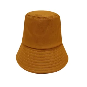 Detail view of the brown cotton bucket hat, showing fine stitching on the wide brim.
