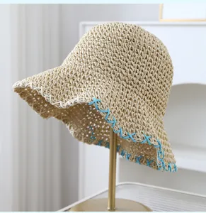 Close-up van handgemaakte strohoed met blauw-witte stiksels, brede rand zomer strandhoed.