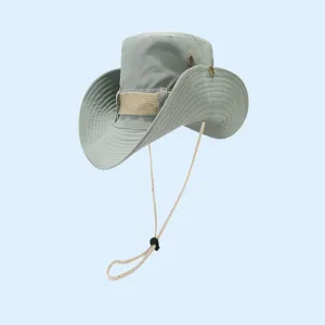 Détail du chapeau de soleil avec large bord, jugulaire réglable et œillets métalliques.