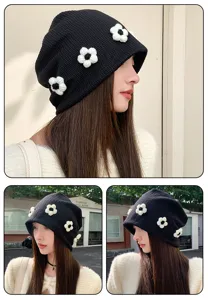Stylish black slouchy knitted hat with white floral embellishments for women winter fashion.