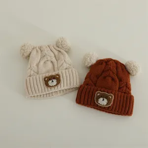 Cute baby knitted beanie set with pom pom ears and adorable bear patch for autumn winter warmth.
