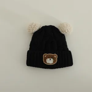 Cute baby knitted hat with pom poms, winter warm infant beanie, adorable bear patch design.
