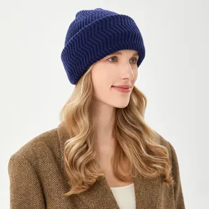 Primo piano di un comodo berretto in maglia blu scuro indossato da una modella.