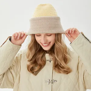 Detailed view of two-tone winter warm knitted bucket hat in yellow and beige colors.