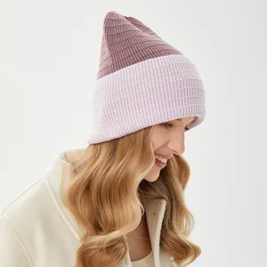 Detailed side view of a stylish two-tone ribbed knit beanie in mauve and light pink.