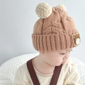 Infant cute bear ear knit hat detail, soft brown wool beanie texture close-up shot.