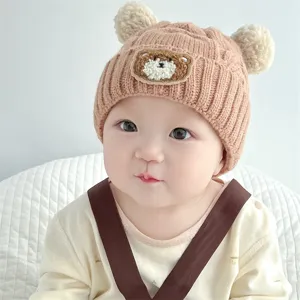 Adorable baby knitted hat with cute bear ears and plush pom-poms for autumn winter warmth.