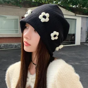 Black knitted slouchy hat for women with 3D white flower embellishments, cute and cool style.