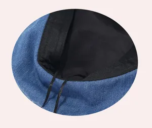 Close-up van de binnenkant van de blauwe denim baret met zwarte voering en verstelbaar koord.