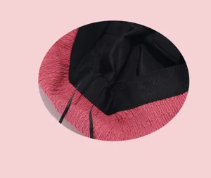Bubble gauze beret interior detail showing fine black lining and pink textured fabric surface.