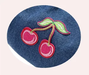 Close-up van blauwe denim baret met mooi roze kersen borduurwerk stijlvolle hoed.